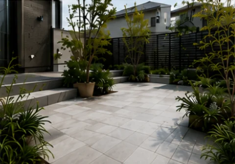 石調タイルのテラスと植栽、黒いフェンスを組み合わせた庭のタイル施工例