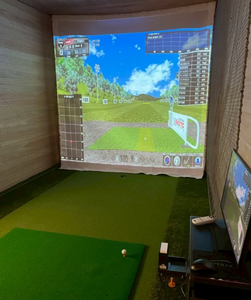 大型スクリーンにゴルフコースが映るシミュレーションゴルフの打席